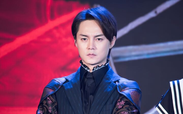 尹正穿黑白西装与粉色玩偶同框,嘴含薯片演绎反萌差,帅气又可爱
